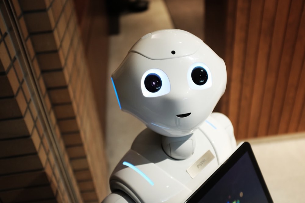 Humanoid robot working alongside automated systems on an automotive factory floor